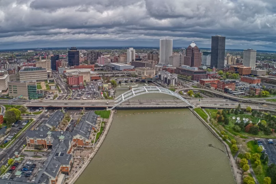 Aerial view of downtown Rochester, New York with river and bridge in foreground.